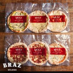 four different types of pizzas wrapped in plastic