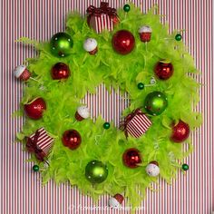 a wreath made out of green feathers and ornaments