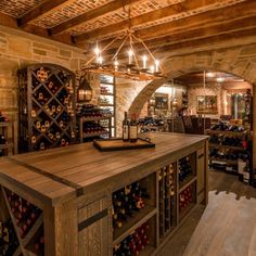 a wine cellar with lots of bottles on the counter and lights hanging from the ceiling