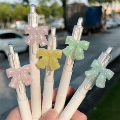 four different colored bows on the top of three white pens in front of a city street