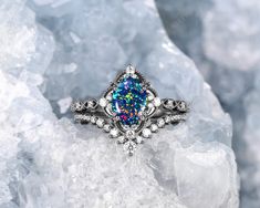 an opal and diamond ring sits on top of ice