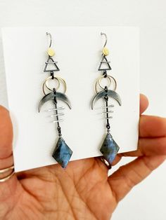 These cosmic sign earrings are rich with cosmic symbols - earth element, solar eclipse, and crescent moon - that together help with emotional balance and to protect against negative energies.  The diamond shaped labradorite is an additional layer of protection. It fills our aura with positivity, giving us the emotional strength and will to go through difficult spiritual transformations. I oxidize and hand finish some of the sterling silver elements to bring out contrast, and achieve an ombre eff Unique Dangle Earrings With Sun And Moon Design, Unique Sun And Moon Dangle Earrings, Unique Sun And Moon Design Dangle Earrings, Unique Moon Phase Metal Earrings, Unique Metal Moon Phase Earrings, Unique Sun And Moon Design Drop Earrings, Unique Sun And Moon Design Earrings As Gift, Sterling Silver Spiritual Earrings With Moon Charm, Spiritual Sterling Silver Earrings With Moon Charm