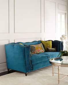 a living room with a blue couch and coffee table in front of a white wall