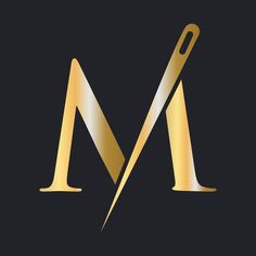 the letter m is made up of gold and silver foil with a large pair of scissors