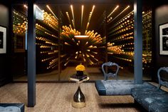 a living room with a bunch of wine bottles on the wall