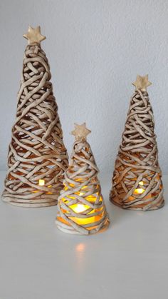 three small christmas trees with candles in them