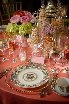 a table set with plates, silverware and wine glasses for an elegant dinner party