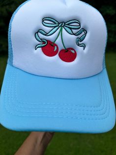 Embroidered bow and cherries trucker cap front adorned with eyelets mesh back with snap closure White Mesh Snapback Hat For Spring, White Trucker Hat With Embroidered Logo For Spring, White Snapback Mini Hats For Spring, Embroidered Summer Trucker Hat With Curved Bill, Summer Trucker Snapback Hat With Embroidered Logo, Trendy Summer Trucker Hat With Embroidered Logo, Custom Embroidered Baseball Cap For Summer, Summer Trucker Hat With Embroidered Logo, Cute Spring Trucker Hat With Curved Brim