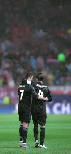 two soccer players hugging each other on the field