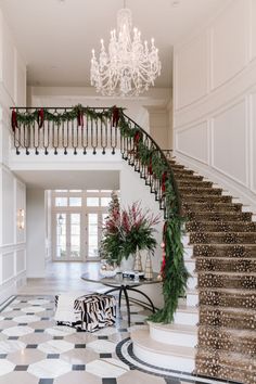 a staircase decorated with greenery and christmas decorations