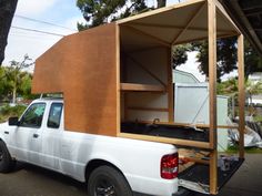 a white truck with a wooden structure in the back