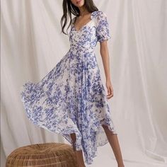 a woman in a blue and white dress is standing next to a wicker basket