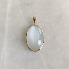 ITEM DESCRIPTION: >>The pendant is made from Solid 14K Yellow Gold. Gemstone used is absolutely natural and ethically sourced.  >>Natural White Moonstones in cabochon cut and oval shape with bezel setting are studded on it with utmost precision.  >>This is a minimalist design and is absolutely hassle-free and everyday jewelry.  ✓ Gem: White Moonstone ✓ Gem size: 18x28 mm oval ✓ Gem weight: 31.48 carats ✓ Gold purity: 14K (58.33% approx.) ✓ Gold weight: 0.78 grams  ✓ Gross weight: 7.08 grams The Gold purity is guaranteed and it comes with authentic 14K gold hallmark. Since these Pendants are handmade, they are Nickel/Lead FREE.  CUSTOMIZATION: --> You can choose your own gemstone as well. --> Main Gemstone can be substituted with the gem of your choice. --> Kindly drop a message for the sam 14k Gold White Jewelry With Si Clarity, White Oval Pendant With Polished Finish, White Moonstone Ring With Si Clarity For Gift, White Gemstone Oval Pendant Jewelry, White Moonstone Oval Pendant Jewelry, White Moonstone Oval Pendant, White Moonstone Oval Cabochon Ring In 14k Gold, White Oval Cabochon Birthstone Jewelry, 14k Gold White Moonstone Oval Cabochon Ring