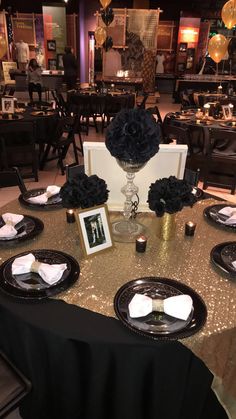 the table is set with black and gold decorations