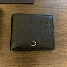 Like New Christian Dior Bifold Wallet, With Black Grained Calfskin And Cd Icon Signature (Finished In Ruthenium Brass). Has Interior Dior Embossing, Snap Button Compartment For Coins, Double Bill Holder Pockets, Two Flat Compartments And Four Card Slots. Includes Original Box And Purchase Bag. Dimensions: 4.5in X 4in. Cd Icon, Bill Holder, Men Dior, Mens Wallet, Leather Bifold Wallet, Bifold Wallet, Wallet Men, Dior Bag, Snap Button