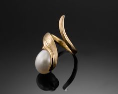 "LIFE" - Classic Collection   DESCRIPTION   - The LIFE ring celebrates the harmony of nature and luxury, inspired by the delicate balance between organic beauty and refined craftsmanship. This design embodies timeless elegance with a contemporary twist, making it a perfect statement of individuality.   - Meticulously crafted in 18K gold, the ring features an 11 x 14 mm freshwater drop pearl, celebrated for its luminous sheen and unique shape. The minimalist yet bold setting highlights the pearl' Ring Unique Design, Gold Ring Unique, Unique Gold Rings, Handmade Gold Ring, Pearl Rings, Ring Elegant, Everyday Ring, Pearl Jewellery, Gold Ring Sets