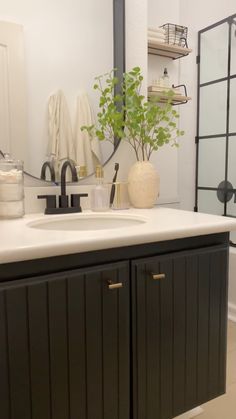 a white sink sitting under a bathroom mirror next to a black and white counter top