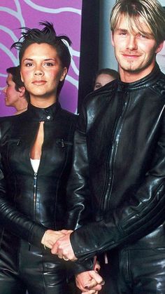 a man and woman dressed in black leathers are standing next to each other holding hands