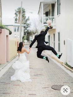 a bride and groom jumping in the air