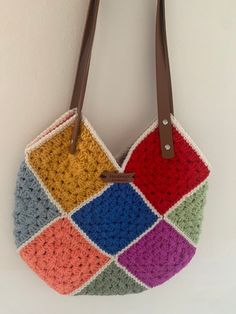 Add a splash of colour to your wardrobe with this beautiful handmade crochet bag! Featuring vibrant, multicoloured yarn and sturdy leather handles, this boho chic tote bag is perfect for any occasion. Whether you're heading to the beach, going on a picnic, or running errands in the city, this unique accessory will make a statement wherever you go. Order Now: Ready to add some color to your life? Click "Add to Cart" to purchase your very own handmade crochet bag today! Everyday Multicolor Crochet Bag With Granny Square, Multicolor Square Crochet Bag With Handles, Multicolor Rectangular Crochet Bag With Handles, Rectangular Multicolor Crochet Bag With Handles, Multicolor Crochet Bag For Shopping, Colorful Crochet Bags For Everyday Use, Multicolor Crochet Tote Bag With Handles, Handmade Multicolor Crochet Tote Bag, Multicolor Crochet Shoulder Bag For Shopping