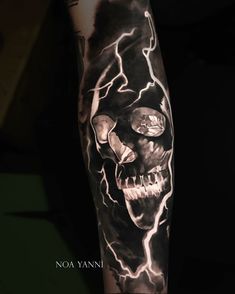 a man's arm with a black and white tattoo on it, featuring a skull