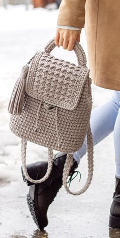 a woman carrying a handbag while walking down the street