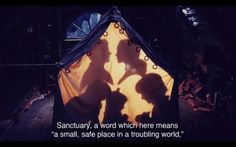 the shadow of two people standing in front of a tent with words on it that read sanctuary, a word which there means'a small safe place in a trouling world