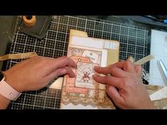 two hands are working on an ornate card