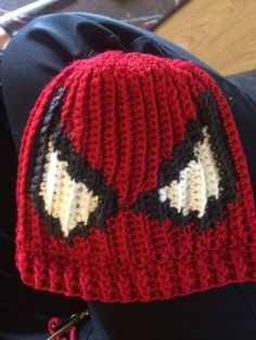 a knitted deadpool hat is shown on someone's back leg and has eyes drawn out