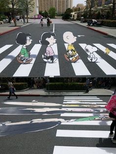 people walking across a crosswalk with cartoon drawings on the ground and in the street