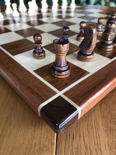 a wooden chess board with pieces on it