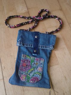 a purse made out of an old pair of jeans with a chain attached to it