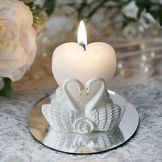 a white heart shaped candle sitting on top of a plate