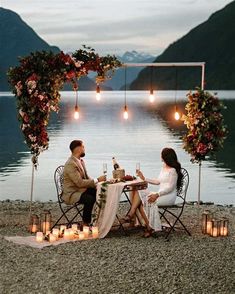 a man and woman sitting at a table with wine glasses in front of the water