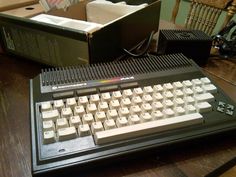 an old typewriter sitting on top of a wooden table next to a box filled with papers