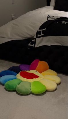 colorful pillows on the floor in front of a bed