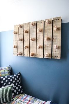 a bedroom with blue walls and wooden pegs on the wall