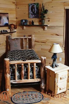 a bedroom with wooden walls and flooring has a bed made out of wood logs