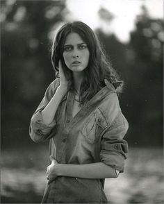 an old black and white photo of a woman in overalls posing for the camera