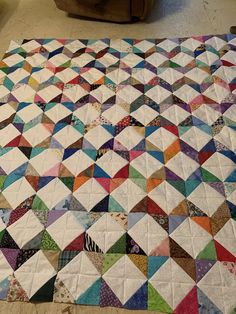 a multicolored quilt is laying on the floor