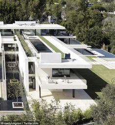 an aerial view of a modern house with trees in the background