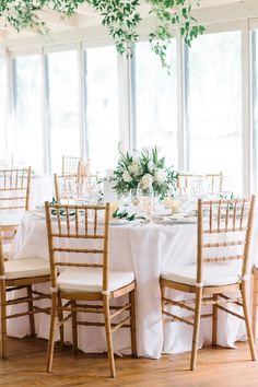 the tables are set with white linens and greenery