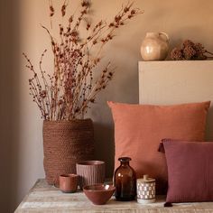 vases and other decorative items sit on a table in front of a wall,