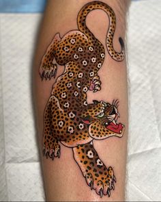 a tattoo on the leg of a person with a leopard design on it's arm