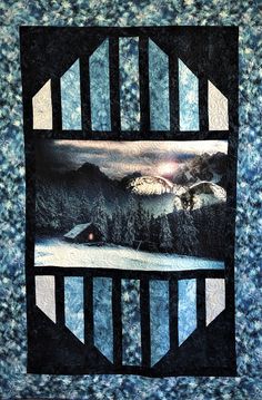 a quilted wall hanging with an image of mountains and trees in the background,