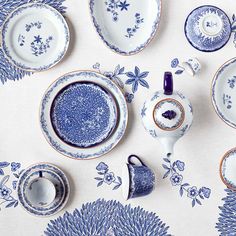 blue and white china is laid out on a table