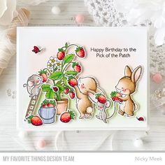 a happy birthday card with two rabbits and strawberries on the top, one is holding a potted plant