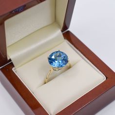 an oval blue topaz ring in a wooden box