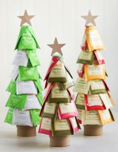 three small christmas trees made out of paper with tags attached to the top and bottom