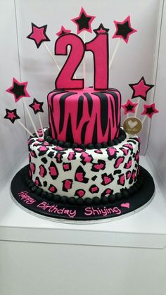 a 21st birthday cake decorated with pink and black icing, stars and zebra print